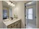 Bathroom featuring a large mirror, stylish lighting, and doorway with adjacent room views at 3958 Windgrove Xing, Suwanee, GA 30024