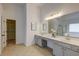 This bathroom features a long vanity with double sinks, a large mirror, and access to a walk-in closet at 3958 Windgrove Xing, Suwanee, GA 30024