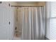 Bright bathroom featuring a white shower curtain, shower head, and window with natural light at 3958 Windgrove Xing, Suwanee, GA 30024