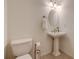 Powder room featuring a pedestal sink, mirror, and a modern toilet at 3958 Windgrove Xing, Suwanee, GA 30024