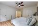 Primary bedroom features wood floors, ceiling fan, and neutral decor at 3958 Windgrove Xing, Suwanee, GA 30024