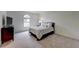 This bedroom showcases a minimalist design, featuring an arched window for natural light and soft carpeted floors at 3958 Windgrove Xing, Suwanee, GA 30024