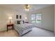 Bright bedroom featuring neutral tones, soft carpet, a ceiling fan, and double windows providing natural light at 3958 Windgrove Xing, Suwanee, GA 30024