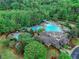 Aerial view of the stunning community pool and clubhouse surrounded by lush landscaping and mature trees at 3958 Windgrove Xing, Suwanee, GA 30024