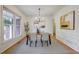 Bright dining room boasts hardwood floors, modern chandelier, and large window at 3958 Windgrove Xing, Suwanee, GA 30024