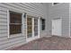 Back of home features gray siding, a brick patio and double doors at 3958 Windgrove Xing, Suwanee, GA 30024