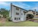Rear view of a two-story house with gray siding, large windows, patio, and mature landscaping at 3958 Windgrove Xing, Suwanee, GA 30024