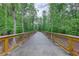 Long wooden bridge on a greenway with sturdy wooden railings, offering a scenic and safe path through nature at 3958 Windgrove Xing, Suwanee, GA 30024