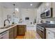 Eat-in kitchen features stainless steel appliances, granite countertops, white cabinets, and an adjacent living room at 3958 Windgrove Xing, Suwanee, GA 30024