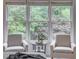 Bright seating area with chairs near window, ideal for relaxation and reading, in a light-filled Primary bedroom at 3958 Windgrove Xing, Suwanee, GA 30024