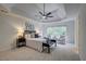 Spacious bedroom featuring a tray ceiling, fan, sitting area, and windows providing natural light at 3958 Windgrove Xing, Suwanee, GA 30024