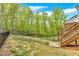 Backyard featuring a wooden staircase and a fenced-in green lawn with mature trees at 409 Retreat Ln, Canton, GA 30114