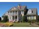 Stately two-story home featuring a welcoming porch, classic columns, and professionally landscaped grounds at 409 Retreat Ln, Canton, GA 30114