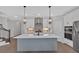 Well-equipped kitchen boasting stainless appliances, a center island with seating, and designer lighting fixtures at 409 Retreat Ln, Canton, GA 30114