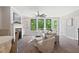 Bright living area with a fireplace, plush seating, and large windows offering a scenic view of the outdoors at 409 Retreat Ln, Canton, GA 30114