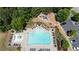 Aerial view of a large community pool featuring sun loungers, tables, umbrellas, and a playground at 409 Retreat Ln, Canton, GA 30114