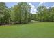 Expansive green backyard with a black fence and beautiful mature trees at 4881 Bill Cheek Rd, Auburn, GA 30011
