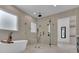 Elegant bathroom featuring a glass enclosed shower, a modern tub, and lots of natural light at 4881 Bill Cheek Rd, Auburn, GA 30011