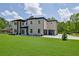 Stunning two-story home with a manicured lawn, modern garage doors, and a sleek black and white design at 4881 Bill Cheek Rd, Auburn, GA 30011