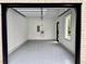 A view of a spacious garage showcasing a modern door, lighting, and epoxy flooring at 4881 Bill Cheek Rd, Auburn, GA 30011