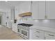 Bright kitchen with stainless steel oven, white cabinets, quartz countertop, and hardwood floors at 4881 Bill Cheek Rd, Auburn, GA 30011
