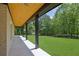 Spacious covered patio with wooden ceiling and sleek posts overlooking a big yard at 4881 Bill Cheek Rd, Auburn, GA 30011