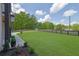 Expansive, well-maintained front yard with a black wooden fence, adding curb appeal at 4881 Bill Cheek Rd, Auburn, GA 30011