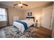 Bedroom with ceiling fan, hardwood floors, blue accents, and a window at 1412 Shelnutt Ct, Hampton, GA 30228