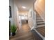 Hallway features hardwood floors, leading to kitchen and staircase with white railing at 1412 Shelnutt Ct, Hampton, GA 30228
