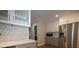 Bright kitchen with white cabinets, stainless steel appliances, marble backsplash, and hardwood flooring at 1412 Shelnutt Ct, Hampton, GA 30228