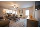 Inviting living room featuring fireplace, ceiling fan, modern floors, and an open floor plan with kitchen view at 1412 Shelnutt Ct, Hampton, GA 30228