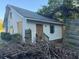 Rear of the house with a door, chimney, siding, and piles of debris at 29 Park Ne Cir, Atlanta, GA 30305