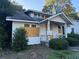 Two-story white house with a chimney, covered porch and boarded-up windows at 29 Park Ne Cir, Atlanta, GA 30305
