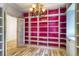 An office/library features a white bookshelf with pink backing and decorative chandelier at 3485 Aubusson Trce, Johns Creek, GA 30022