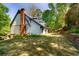 Spacious backyard features a brick chimney, mature trees, and tiered landscaping for outdoor enjoyment at 3485 Aubusson Trce, Johns Creek, GA 30022