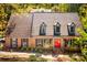 Charming brick home with an orange double-door entrance and mature landscaping, and dormer windows at 3485 Aubusson Trce, Johns Creek, GA 30022