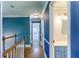 Hallway with blue walls, white trim, hardwood floors, and access to a bathroom at 3485 Aubusson Trce, Johns Creek, GA 30022
