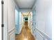 Hallway with wainscoting, hardwood floors, and doorway leading to a cozy living room at 3485 Aubusson Trce, Johns Creek, GA 30022