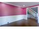 Room with pink walls, white wainscoting and trim, and gleaming hardwood floors with staircase view at 3485 Aubusson Trce, Johns Creek, GA 30022