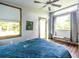 Bright bedroom featuring wood-trimmed windows, shades, a bench, and stylish blue quilted bedding at 991 Columbia Dr, Decatur, GA 30030