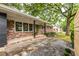 A red brick home features dark columns, a green front door, and a stone and gravel walkway at 991 Columbia Dr, Decatur, GA 30030