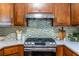 Up close view of the range in the updated kitchen with stainless steel hood vent and mosaic backsplash at 991 Columbia Dr, Decatur, GA 30030