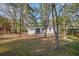 White home, surrounded by mature trees on a lawn with pine straw at 331 Zelma Sw St, Marietta, GA 30060