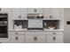 Modern kitchen with stainless steel oven, white cabinets, and gray tiled backsplash at 1143 Brookhaven North Cir, Brookhaven, GA 30319