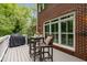 Outdoor patio with brick exterior and small wooden table and chairs at 1143 Brookhaven North Cir, Brookhaven, GA 30319