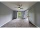 Large bedroom featuring neutral carpet, ceiling fan, and door leading to outdoor space at 27306 Plantation Ne Dr, Atlanta, GA 30324