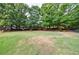 Expansive lawn area with mature trees and building in the background at 27306 Plantation Ne Dr, Atlanta, GA 30324