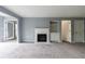 Open-concept living room featuring fireplace, built-in shelving, plush carpeting and neutral grey color at 27306 Plantation Ne Dr, Atlanta, GA 30324