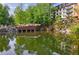 Scenic view of the pond with a waterfall feature and building in the background, surrounded by lush greenery at 27306 Plantation Ne Dr, Atlanta, GA 30324
