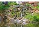 Cascading waterfall on rocky cliffside into a pond is an oasis in this community at 27306 Plantation Ne Dr, Atlanta, GA 30324